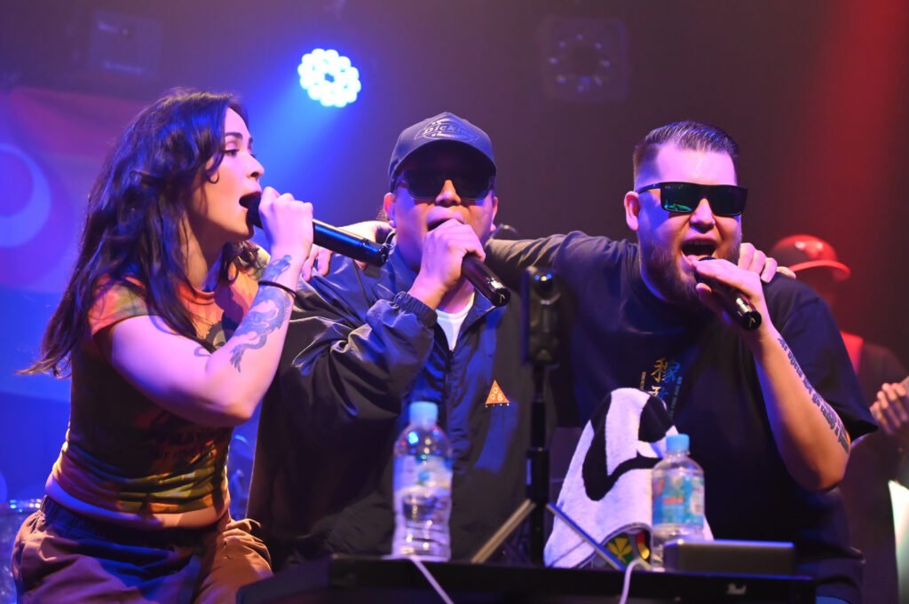 Shima Vibez vocalists and Juicyman performing live on stage under colorful concert lighting